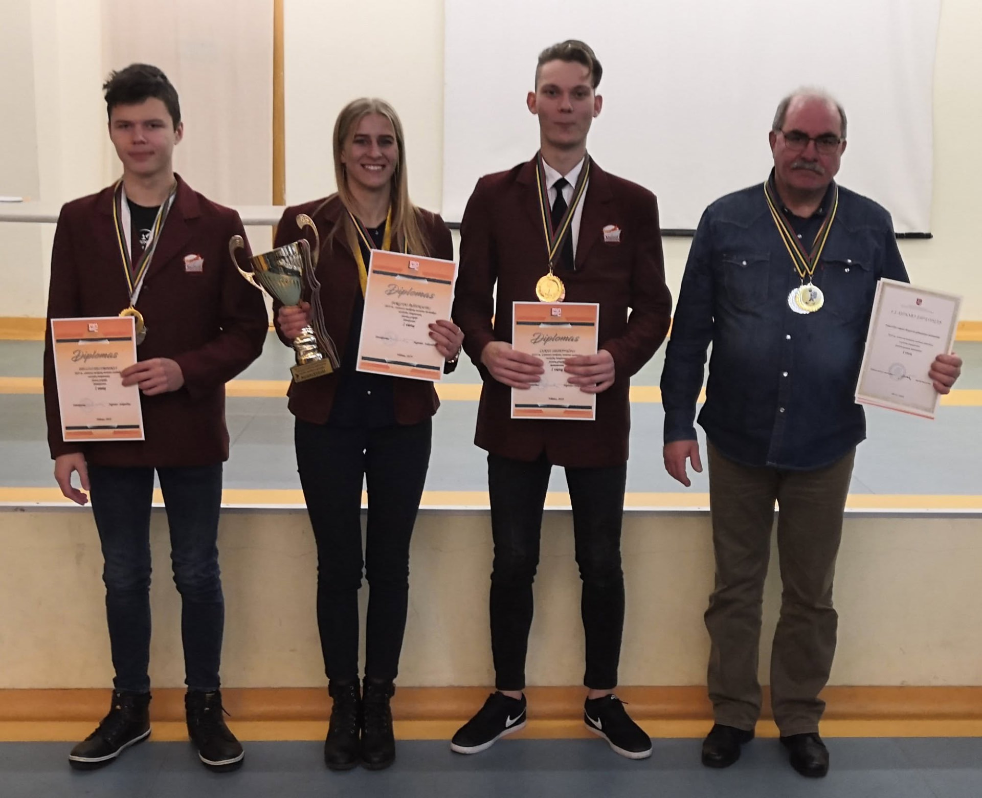 Senior athletes with medals and trophy